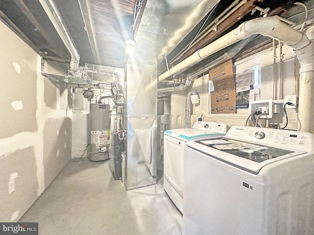 clothes washing area with washing machine and dryer and gas water heater