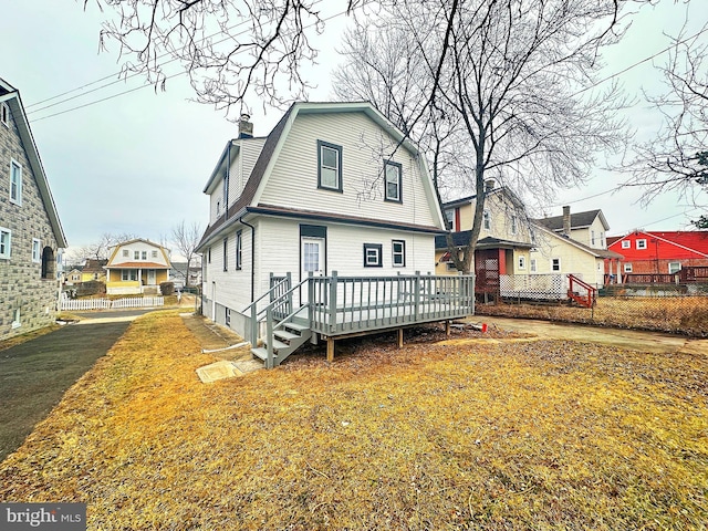 view of front of house with a deck and a front lawn