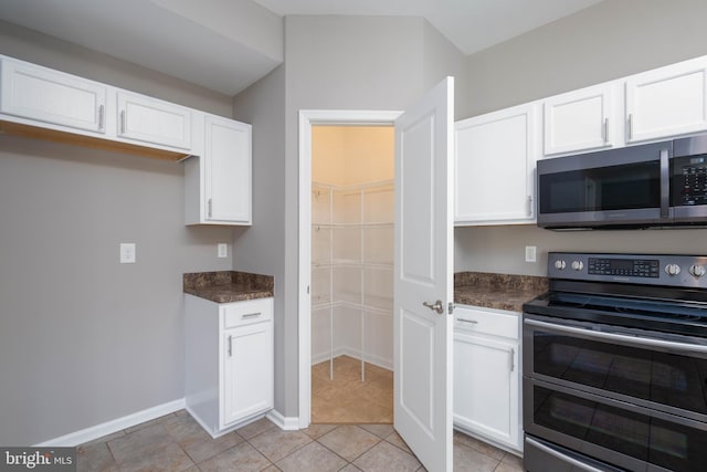 kitchen with white cabinetry, light tile patterned flooring, and appliances with stainless steel finishes