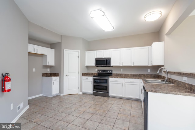 kitchen with light tile patterned flooring, appliances with stainless steel finishes, sink, and white cabinets