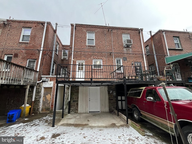 snow covered house featuring cooling unit and a deck