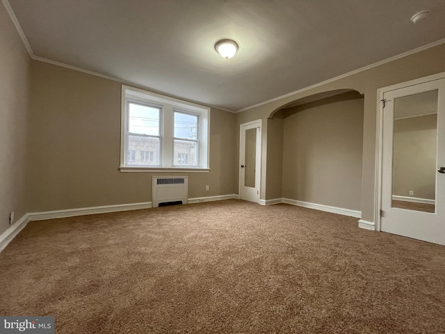 carpeted empty room featuring crown molding and radiator heating unit