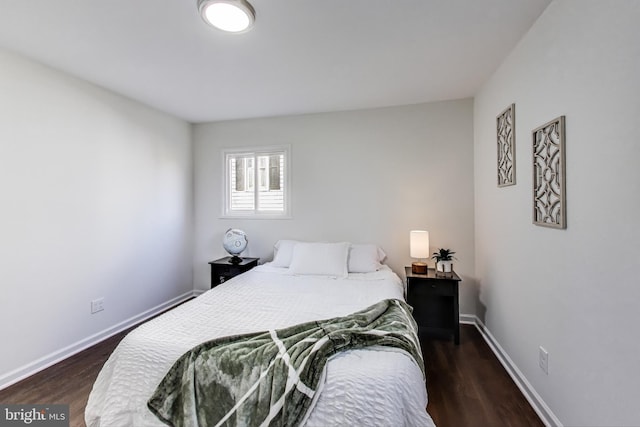 bedroom with dark hardwood / wood-style flooring