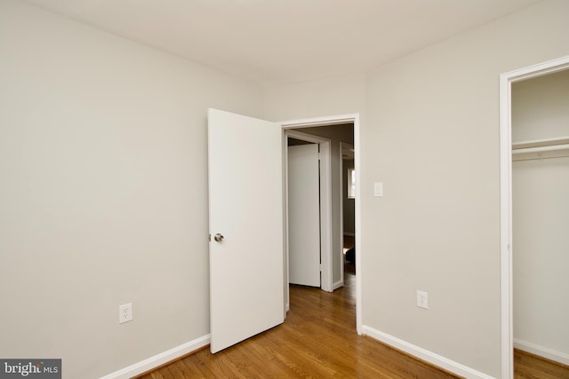 unfurnished bedroom featuring wood-type flooring and a closet