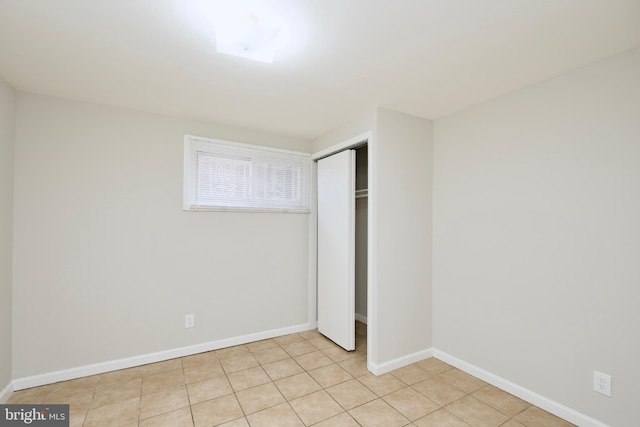 unfurnished bedroom with light tile patterned floors and a closet