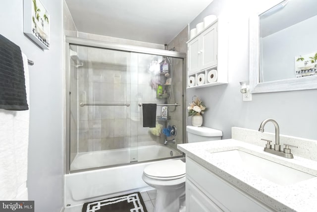 bathroom featuring toilet, tile patterned floors, enclosed tub / shower combo, and vanity