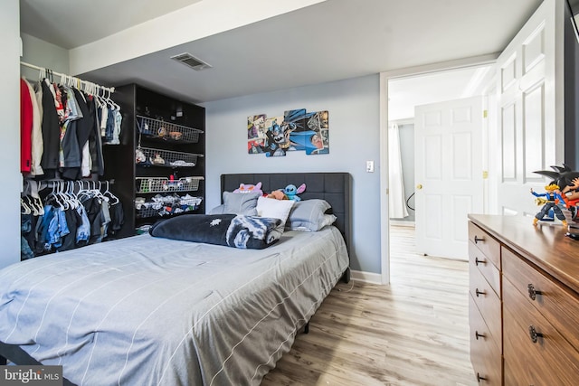 bedroom featuring light wood-type flooring, baseboards, and visible vents