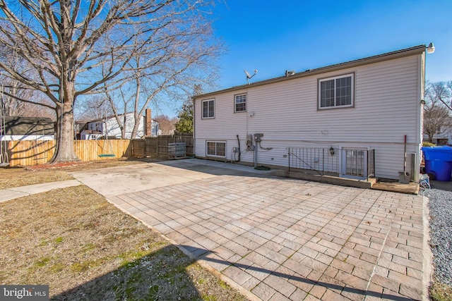 rear view of property featuring a patio and fence