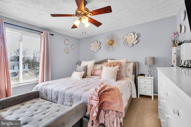 bedroom featuring a ceiling fan, light carpet, and a textured ceiling