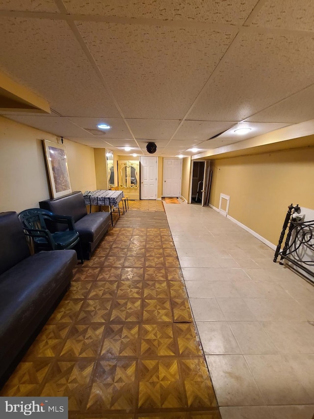 recreation room with a paneled ceiling and parquet flooring