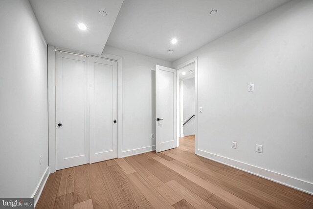 unfurnished bedroom featuring light wood-type flooring and a closet