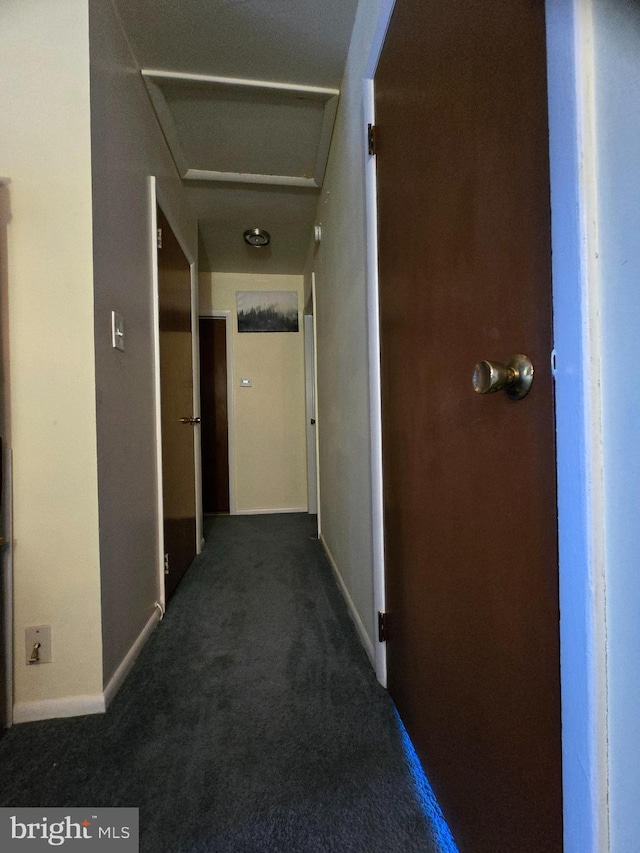 hall with dark colored carpet