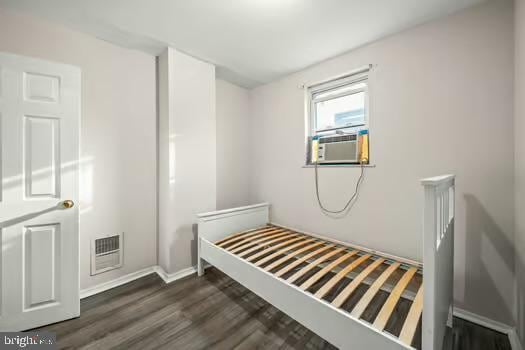 bedroom featuring cooling unit and dark wood-type flooring