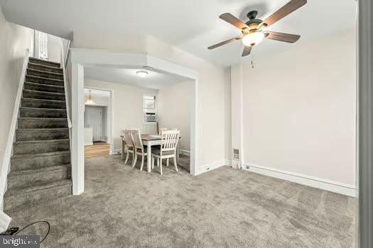 unfurnished dining area with carpet and ceiling fan