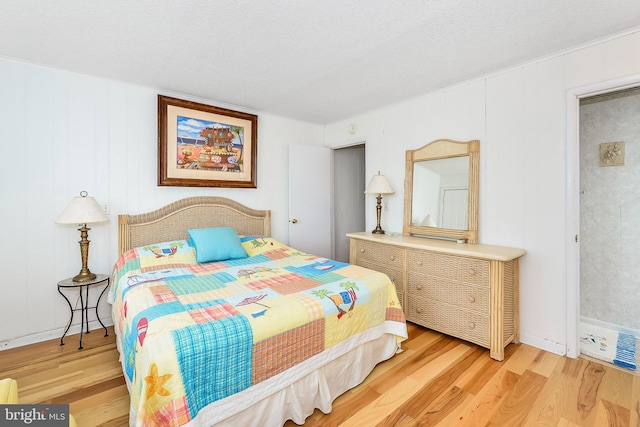 bedroom featuring light hardwood / wood-style floors and a textured ceiling