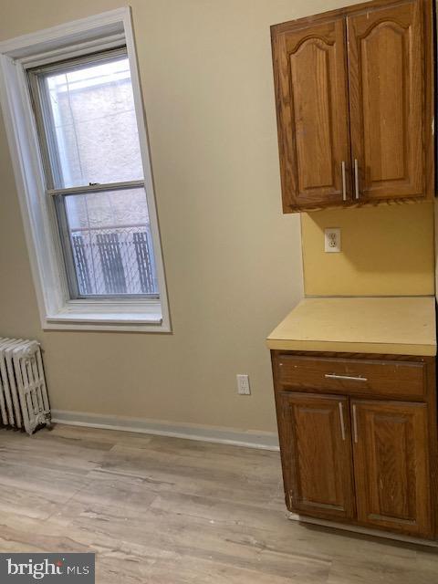 kitchen with radiator heating unit and light hardwood / wood-style flooring