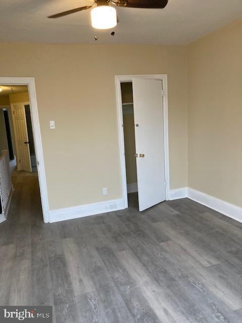 empty room with dark hardwood / wood-style flooring and ceiling fan