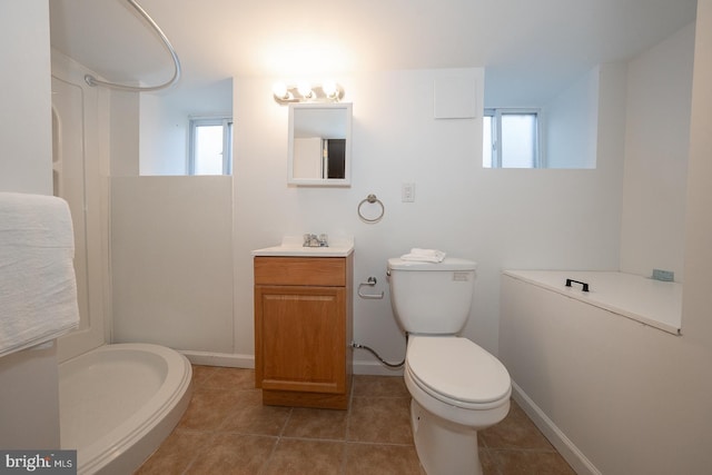 bathroom with vanity, plenty of natural light, tile patterned floors, and toilet