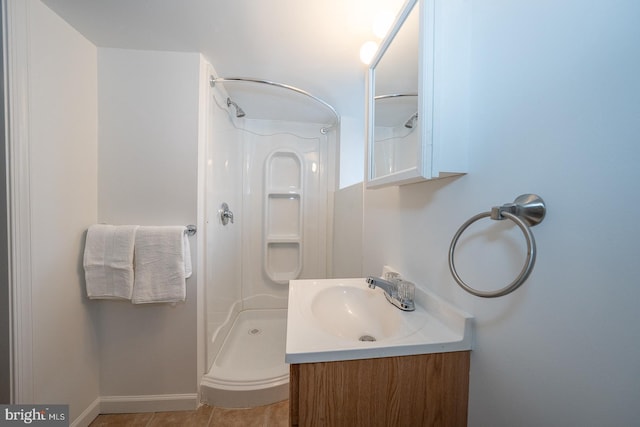 bathroom with a shower, vanity, and tile patterned floors