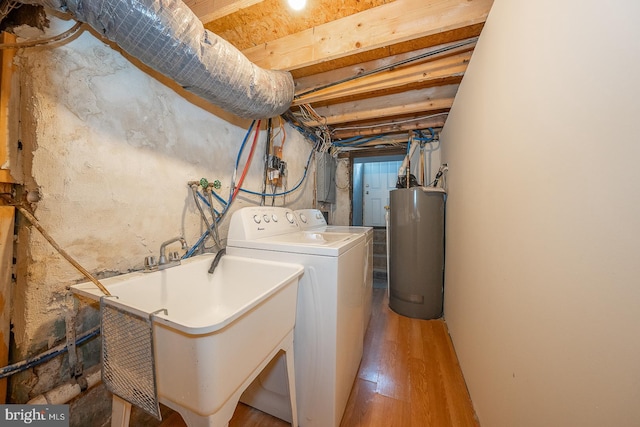 washroom with washer / clothes dryer, sink, water heater, and light wood-type flooring