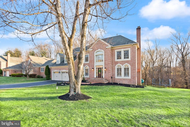 view of front of property with a trampoline, a garage, and a front yard