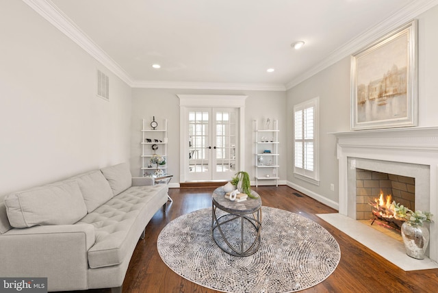 living room with crown molding, dark hardwood / wood-style flooring, and french doors