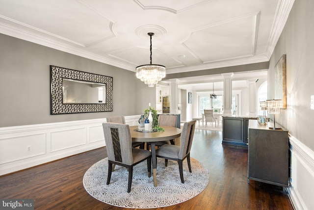 dining room with dark hardwood / wood-style flooring, ornamental molding, decorative columns, and an inviting chandelier