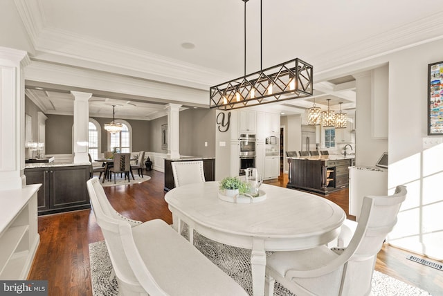 dining room featuring crown molding, an inviting chandelier, dark hardwood / wood-style floors, coffered ceiling, and ornate columns