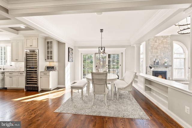 dining area featuring crown molding, plenty of natural light, dark wood-type flooring, and beverage cooler