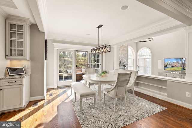 dining room with ornamental molding, light hardwood / wood-style floors, and ornate columns