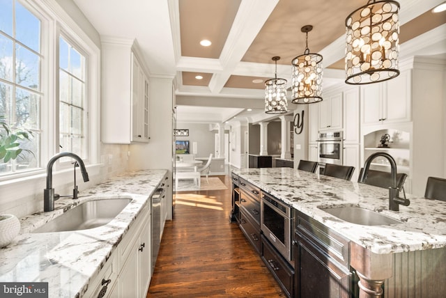 kitchen featuring white cabinetry, appliances with stainless steel finishes, sink, and a kitchen breakfast bar