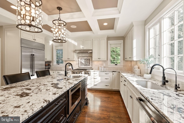 kitchen with pendant lighting, a kitchen bar, light stone countertops, and appliances with stainless steel finishes