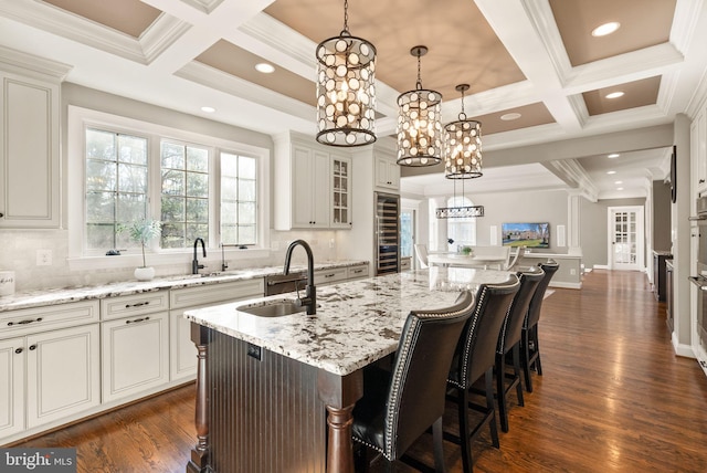 kitchen featuring sink, a kitchen breakfast bar, an island with sink, and hanging light fixtures