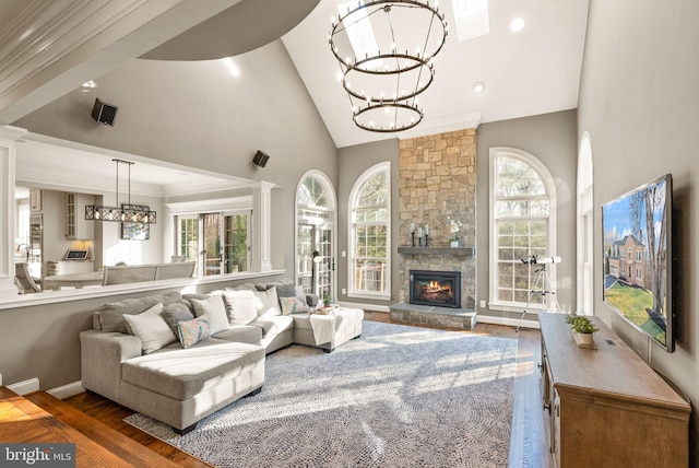 living room featuring hardwood / wood-style flooring, high vaulted ceiling, a healthy amount of sunlight, and a fireplace