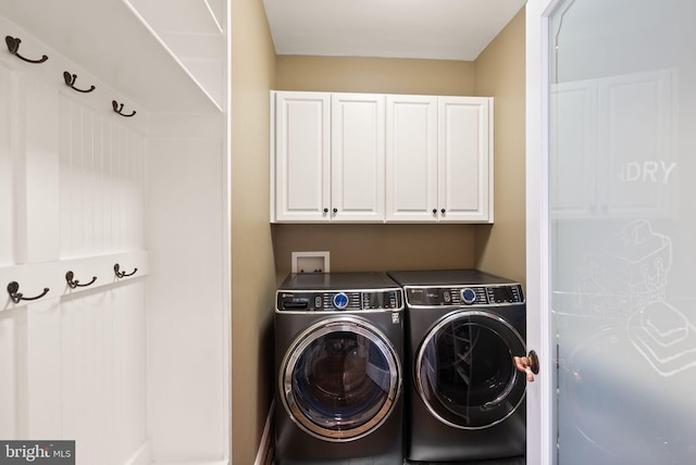 laundry room featuring cabinets and washing machine and clothes dryer