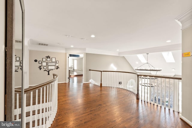 hallway with a notable chandelier, crown molding, dark wood-type flooring, and lofted ceiling with skylight