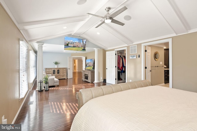 bedroom featuring ornate columns, lofted ceiling with beams, a spacious closet, ceiling fan, and dark wood-type flooring