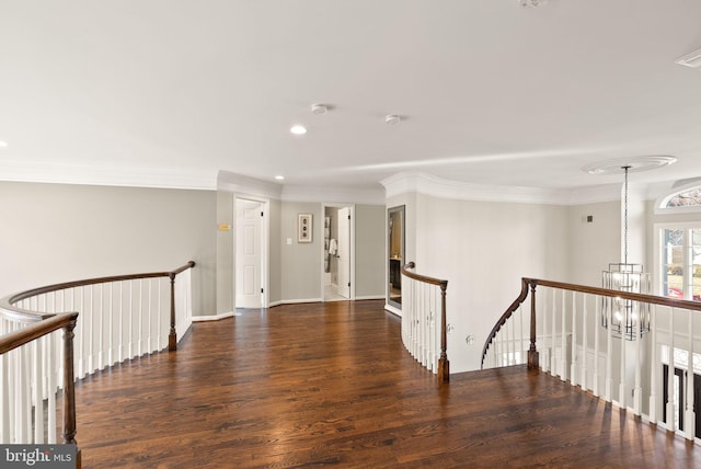 hall with a notable chandelier, ornamental molding, and dark hardwood / wood-style floors