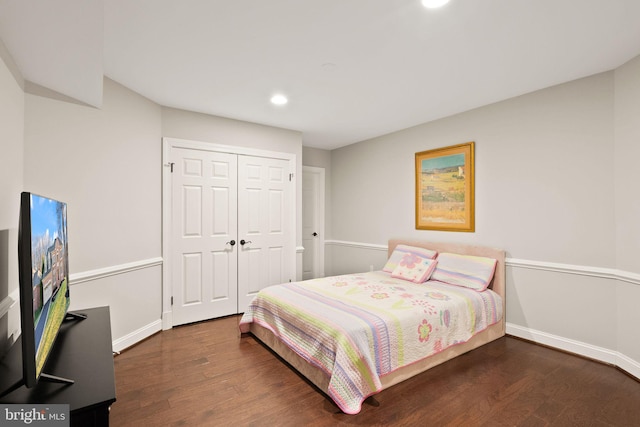 bedroom with dark hardwood / wood-style floors and a closet