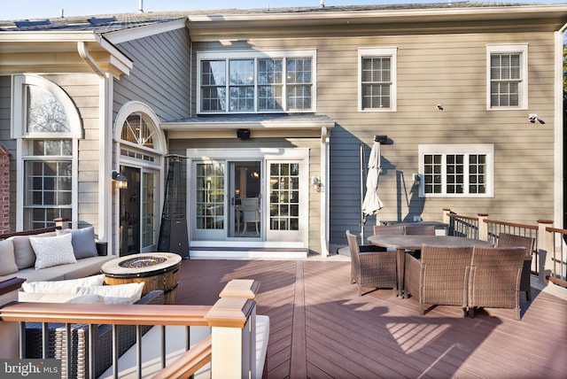 wooden terrace with an outdoor living space with a fire pit