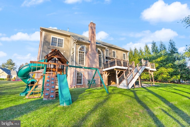 rear view of property featuring a playground and a yard