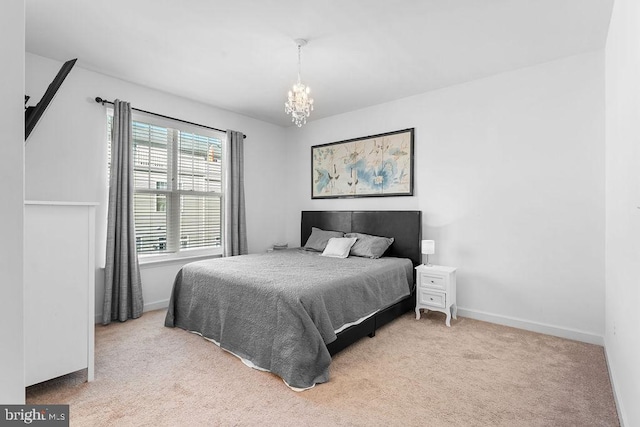 bedroom with an inviting chandelier and light carpet