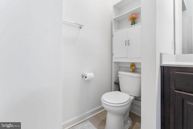 bathroom with tile patterned flooring, vanity, and toilet