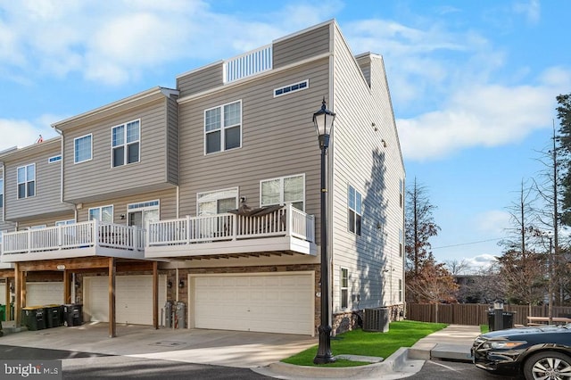 back of house with a garage, a balcony, and central air condition unit