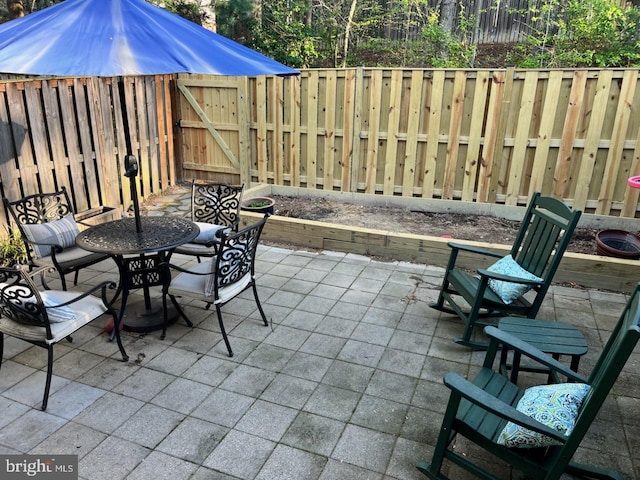12240 Nutmeg Ct, Woodbridge, VA 22192 - view of patio featuring a fenced backyard, a gate, and outdoor dining area