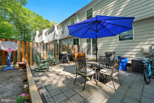12240 Nutmeg Ct, Woodbridge, VA 22192 - view of patio / terrace with fence, outdoor dining area, and cooling unit