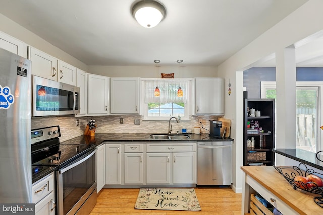12240 Nutmeg Ct, Woodbridge, VA 22192 - kitchen with a sink, tasteful backsplash, stainless steel appliances, and light wood-type flooring