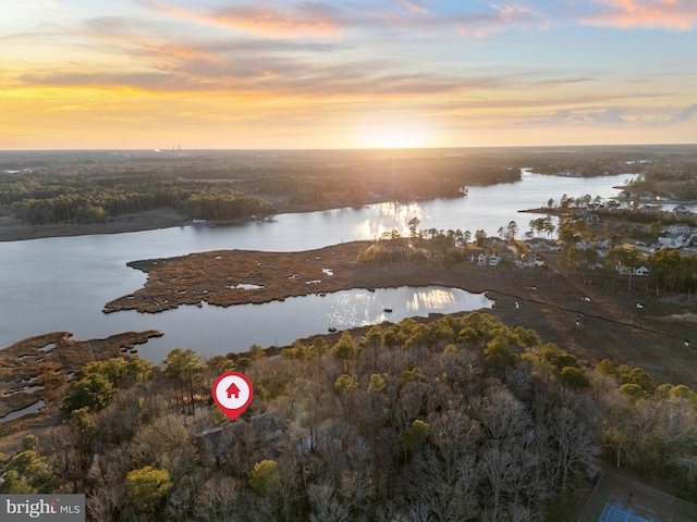 aerial view at dusk featuring a water view