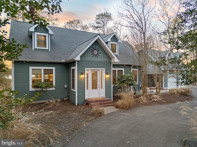 cape cod home featuring a garage