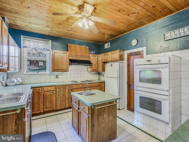 kitchen with white appliances, sink, an island with sink, and light tile patterned floors